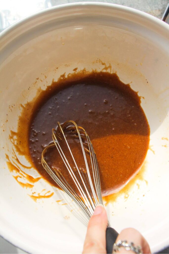 Whisking butter and sugar in a mixing bowl.